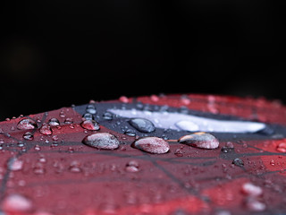 THREE ISOLATED DROPS OF RAIN ON A RED CLOTH
