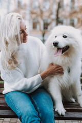 Young woman embracing her white lovely dog