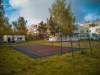 Sports ground in courtyard of residential complex. Public sports grounds for team games of sport, basketball, football, volleyball, handball in residential area, of educational institutions city