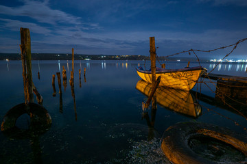 Fishing pier at night with drone imitating northern Aurora Borealis lights