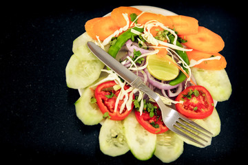 top view on original salad made from assorted sliced vegetables served with fork