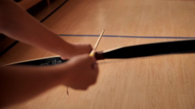 The archer shoots a bow and misses. Preparing for shooting indoor archery. The archer inserts an arrow into the bow to fire and raises the weapon to fire. Archery shot at target.