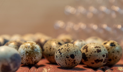 Obraz premium Quail eggs on red wooden surface on blurred background