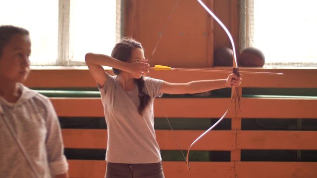 The archer shoots a bow and misses. Preparing for shooting indoor archery. The archer inserts an arrow into the bow to fire and raises the weapon to fire. Archery shot at target.