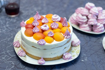 Apricot cake with marshmallow and white cream on festive table