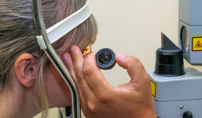 Woman UNERGO eyes test. Ocular fundus. Visit to the doctor.