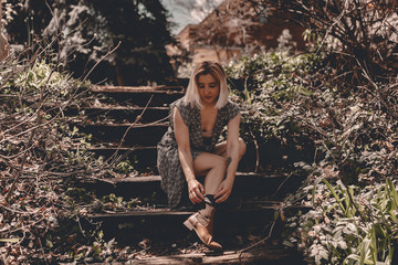Young hipster woman travels in Colorado forest. Long dress, chelsea boots, black hat. Blonde millennial lady. Freedom. Escape home. Local traveling. Exploring places. Travel locally. Travel anxiety.