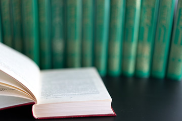 Open book on the background of other books