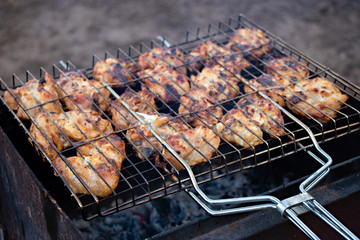 Cooking chicken barbecue on grill in the open air. Concept of picnic in countryside