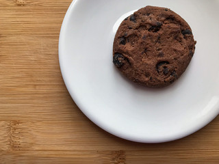homemade cookie with chocolate on white plate and wooden desk