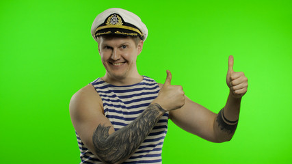 Young sailor man thumbs up, looking at camera. Seaman guy in sailor's vest