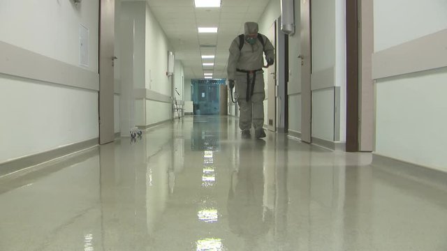 Military personnel in chemical protection suits carry out disinfection and decontamination in the premises of the building.Elimination of the consequences of the pandemic and foci of infection.