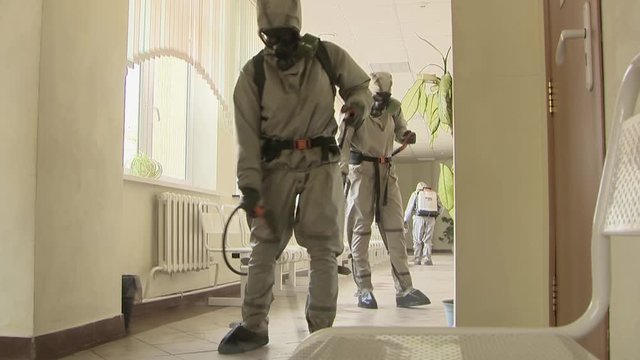 Military personnel in chemical protection suits carry out disinfection and decontamination in the premises of the building.Elimination of the consequences of the pandemic and foci of infection.