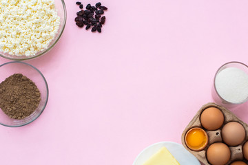 on a pink background, products for the preparation of casserole cottage cheese. Eggs, cottage cheese, raisins, sugar, butter, flaxseed flour. household chores. stay home. recipe. Copyspace. Flat lay