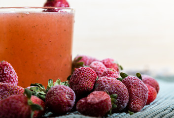 Strawberry juice (Fragaria × ananassa) and frozen fruits on white background