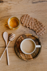Healthy snack set with coffee and chocolate waffles and honey on wooden background. 