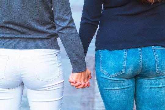 young girls hold each other's hands. Women hold hands together, closeup fanny, ass. The concept of same-sex relationships, LGBT people, lisbians