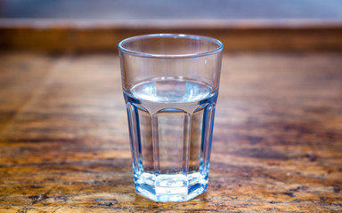 close-up of glass with water on rustic wooden table