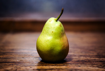 close-up of a pear on rustic wooden table