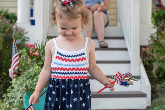 Little Girl Wearing Red White And Blue And Holding A Pinwheel To Celebrate The Fourth Of July