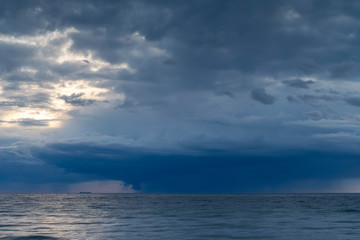 Fototapeta na wymiar Heavy rainfall over ocean during sunset