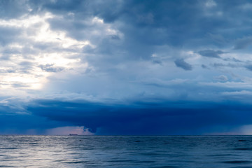 Heavy rainfall over ocean during sunset
