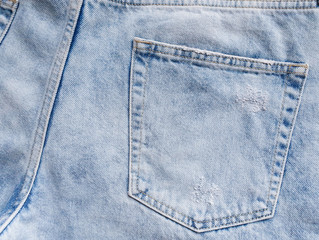 This is a pocket on men's jeans. Denim is light blue. Flat lay.