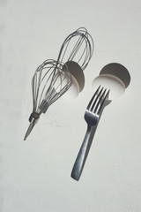 Egg with shadow from the fork. Minimalism. Cooking pastries, omelets. Easy.Whisk for whipping.