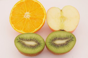 Fototapeta premium una naranja una manzana y dos kiwis partidos por la mitas, zumo, fruta jugosa, fresco, jugoso, vitaminas, sabroso.