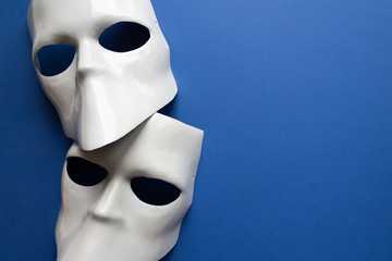 Theatre concept with the white masks on classic blue background. Anonimous, Incognito, Conspiracy...