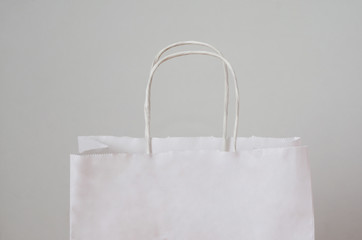 white paper bag with handles for shopping on a white background