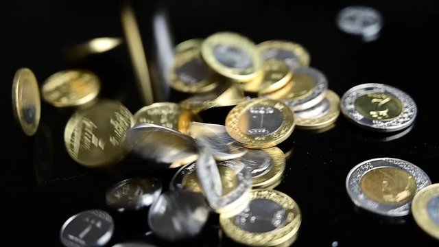 Pile of Saudi Arabian currency (Saudi Riyal) coins fall black background