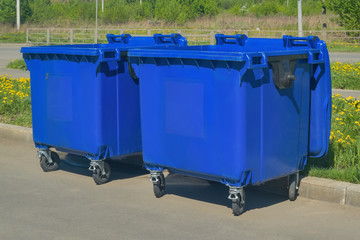 Two plastic trash recycling containers. Blue containers for collecting garbage on the dustbin.