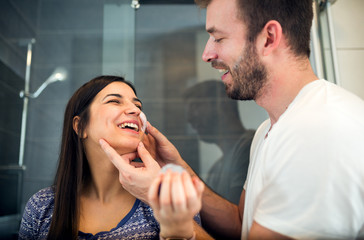 Man applying face cream on his girlfriend