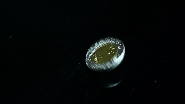Saudi Riyal Coin Spinning on black reflector background in slow motion. Saudi Arabia Currency.