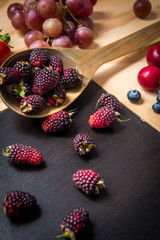 Blackberries and red fruits on a wooden surface