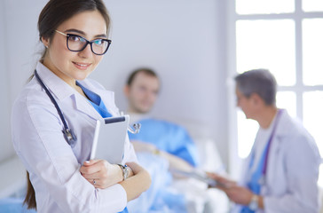 Female doctor using tablet computer in hospital lobby