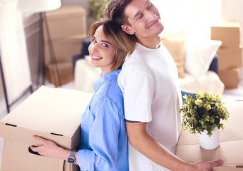 Obraz premium Couple holding boxes for moving the hands and looking inside box