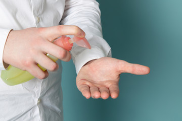 a front view young man in white shirt using spray on the blue background