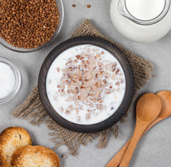 Milk buckwheat soup in a wooden bowl in rustic style on a light background top view