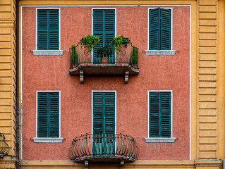 Fototapeta na wymiar A well kept old building with two different shaped balconies in Verona Italy