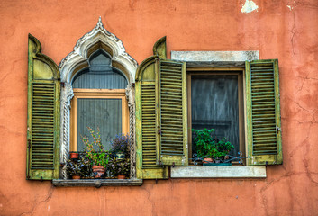 Fototapeta na wymiar A beautiful medieval window next to a newish window in Verona Italy