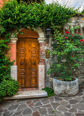 Fototapeta na wymiar A beautiful old wooden door surrounded by plants in old town Verona Italy