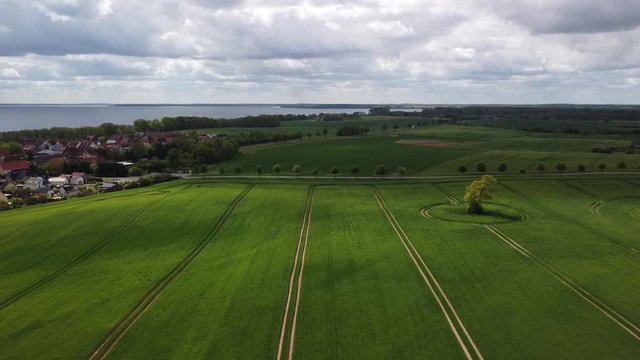 gr&uuml;nes Feld und Schwenk zum See