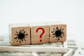 Wooden cube block shape with sign question mark and Covid-19 coronavirus symbol on Japanese yen...
