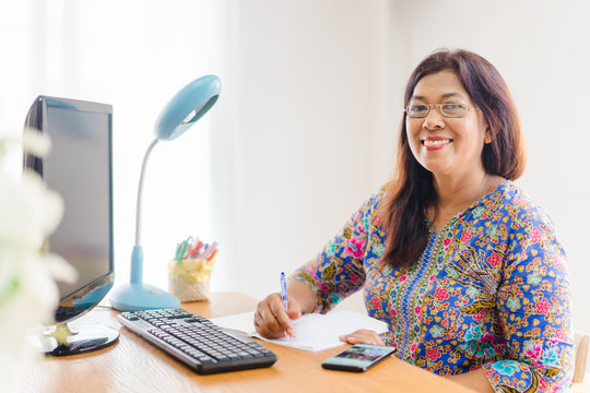 Asian senior woman smiling wearing eye glasses teaching online, Happy woman teach from home Online learning.Happy thumb up woman teacher at home.Social distancing.Online education.home school online.