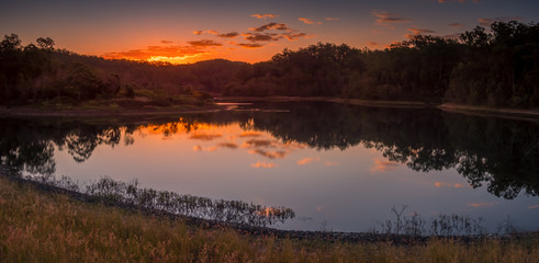 Fototapeta na wymiar Panoramic Lakeside Sunset with Cloud Reflections
