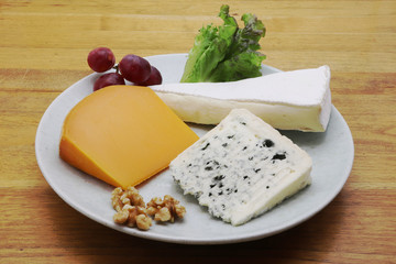 Assorted French cheese on a plate (Mimolette, Brie and blue cheese)