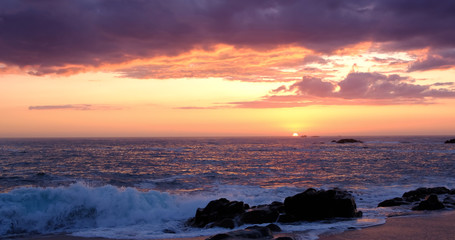 Sun on horizon at sunset in Portugal with beautiful vivid sky. Wide angle.