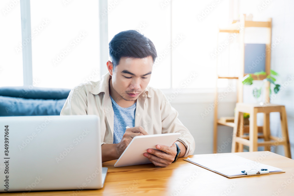 Fototapete Working from home web designing graphical user interface UX UI, home office using computer laptop and pen sketching on tablet device creative planning innovative ideas, asian man quarantine isolation